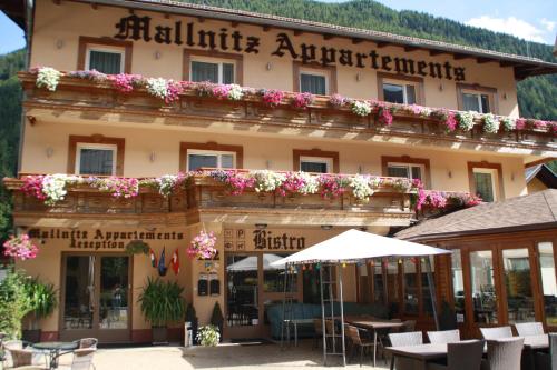 a hotel in the mountains with flowers on the facade at Hotel Mallnitz in Mallnitz