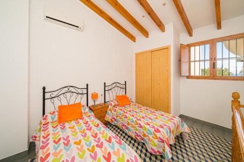 two beds in a room with white walls at Villajoyosa Arsenal in Villajoyosa
