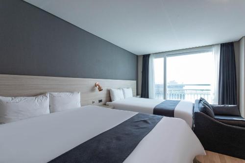 a hotel room with two beds and a window at Gyeongpo Soo Hotel in Gangneung