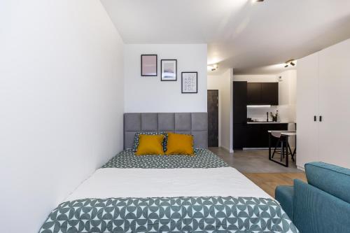 een slaapkamer met een bed en een blauwe bank bij Cloud9 - Barska 69 in Krakau