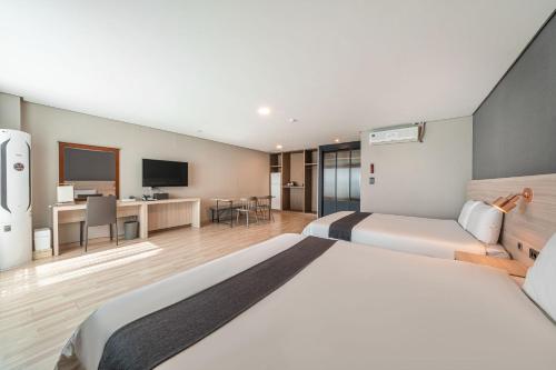 a hotel room with a bed and a desk at Gyeongpo Soo Hotel in Gangneung
