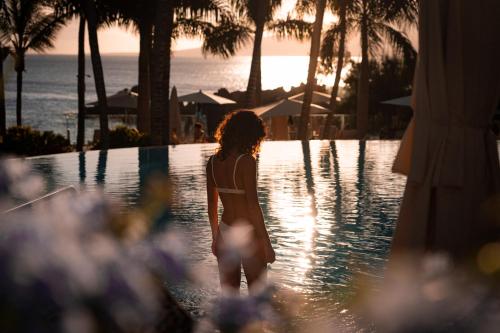 a woman standing in the water near a swimming pool at Hotel Fariones in Puerto del Carmen