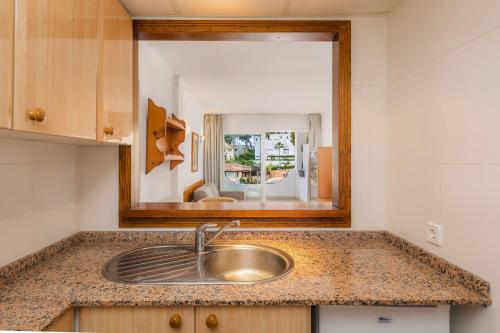 a sink in a kitchen with a mirror at Apto con Terraza 6 in Paguera