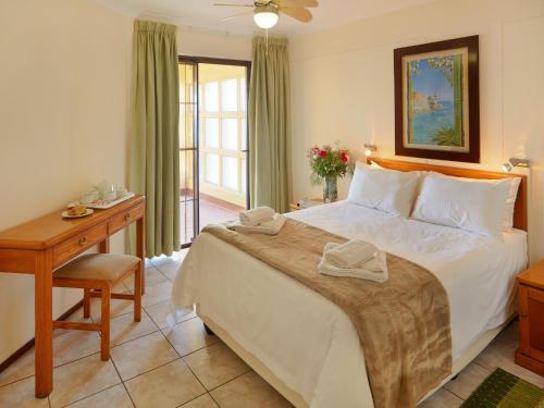 a bedroom with a large bed and a desk and a bed at First Group Costa Smeralda in Margate