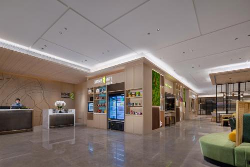 eine Lobby eines Ladens mit einer Person in der Mitte in der Unterkunft Home2 Suites By Hilton Wuhan Hankou Railway Station in Wuhan