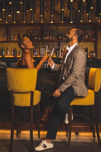 a man and a woman sitting in a bar drinking at Hotel Fariones in Puerto del Carmen