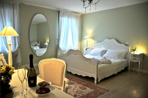 a bedroom with a large white bed and a mirror at Villa Chiopris in Chiópris-Viscone