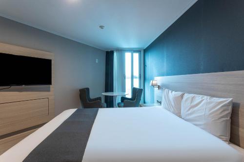 a hotel room with a large bed and a tv at Gyeongpo Soo Hotel in Gangneung
