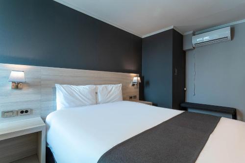 a bedroom with a large white bed and a desk at Gyeongpo Soo Hotel in Gangneung