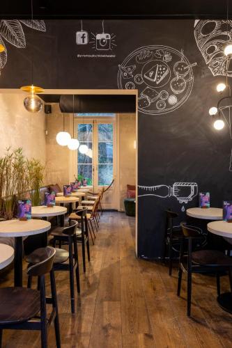 a restaurant with tables and chairs and a wall with drawings on it at B&B Utrecht Domkwartier in Utrecht