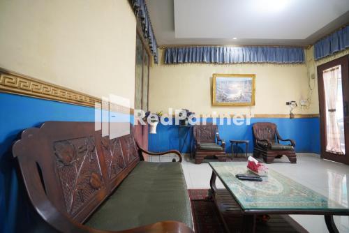 una stanza con sedie e tavolo e pareti blu di Hotel Surabaya Jaya Bandara Soetta a Rawalembang