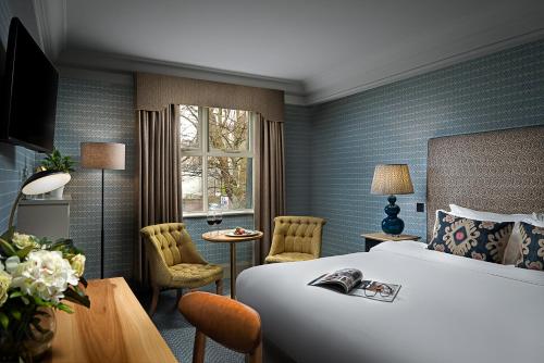 ダブリンにあるスクールハウス ホテルのベッド、テーブル、椅子が備わるホテルルームです。