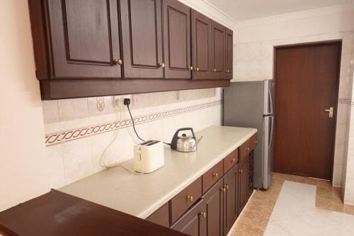 內羅畢的住宿－Capital Apartments- Hendred Road，厨房配有木制橱柜和台面上的用具