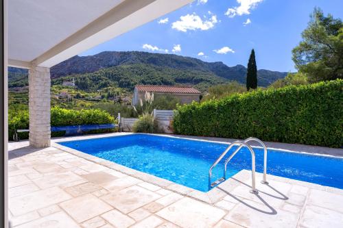 uma piscina numa villa com montanhas ao fundo em Villa Anouk em Pitve