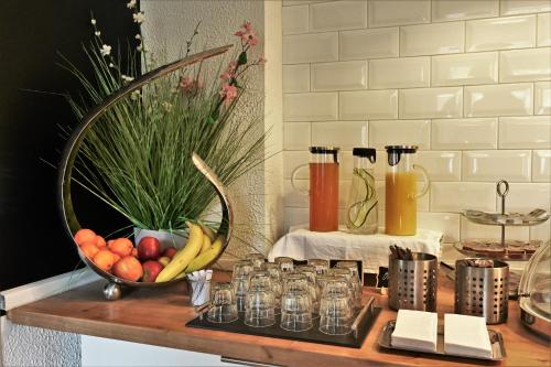 a counter with a bowl of fruit and glasses on it at Les Nations in Berlin