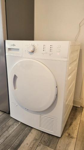 - un lave-linge et un sèche-linge blancs installés à même le sol dans l'établissement Logement spacieux - Face à la gare et centre-ville, à Épinal