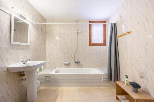ein weißes Badezimmer mit einer Badewanne und einem Waschbecken in der Unterkunft Casa Rural La Clau in Polop