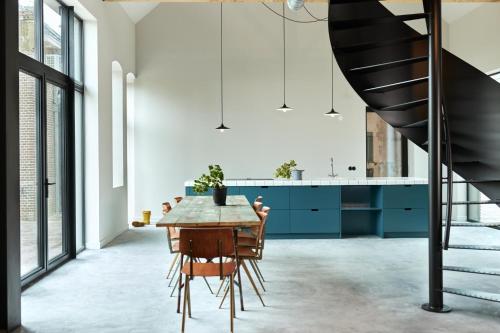 a kitchen with blue cabinets and a wooden table at Suvelfabryk in Lioessens