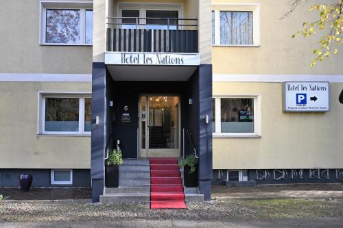 einer Eingangstür eines Gebäudes mit einem roten Teppich in der Unterkunft Les Nations in Berlin