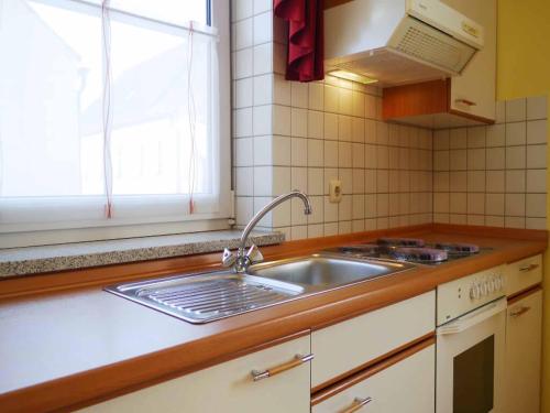 um balcão de cozinha com um lavatório e uma janela em Da`Sporrer Hotel & Wirtshaus em Neunburg vorm Wald