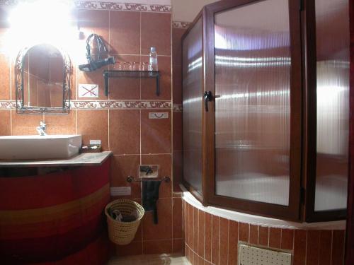 a bathroom with a shower and a sink and a mirror at Hotel Tomboctou in Tinerhir