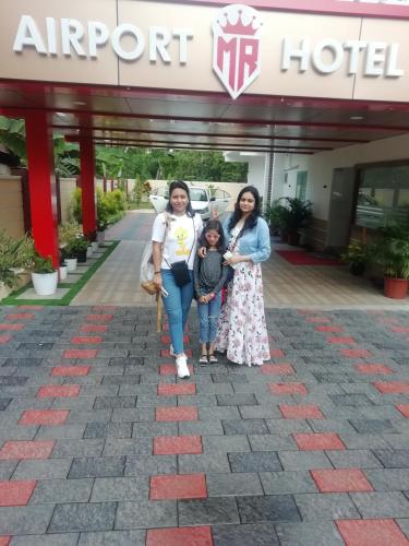 three women and a child standing in front of an airport hotel at MARINA SUITES AIRPORT HOTEL in Cochin