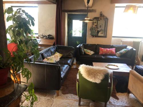 ein Wohnzimmer mit 2 Sofas und einem Tisch in der Unterkunft Superbe maison familiale proche lacs et canal in Beurizot