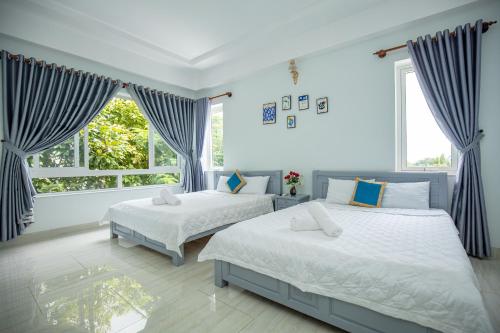 a bedroom with two beds and a window at Gia Nguyễn Villa Vũng Tàu in Vung Tau