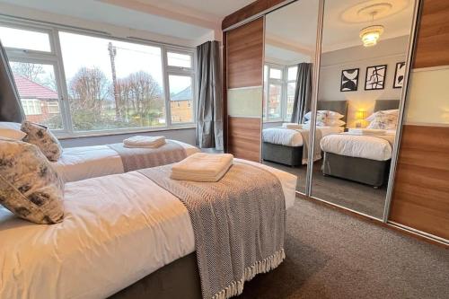 1 dormitorio con 2 camas y un espejo grande en Chelwood Residence, en Moortown