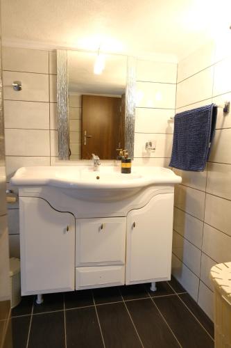 ein Badezimmer mit einem weißen Waschbecken und einem Spiegel in der Unterkunft CHEZ KYRIAKI in Kavala