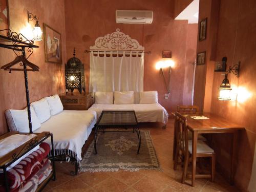 ein Schlafzimmer mit einem Bett und einem Tisch in einem Zimmer in der Unterkunft Hotel Tomboctou in Tinghir