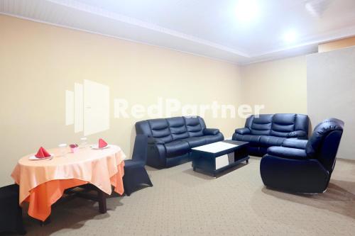 a red partner waiting room with chairs and a table at Edotel Syariah Nilam Sari Mitra RedDoorz in Pekanbaru