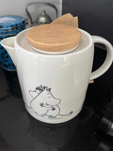 a white cup with a picture of a dog on it at Hienoa talo porealtaalla lähellä Helsinkiä ja lentokenttää in Tuusula