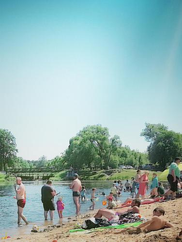 a group of people on the beach near the water at FORMA Apartament Supraśl in Supraśl