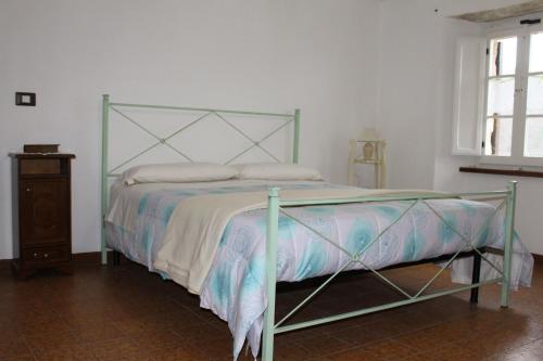 a bed with a green frame in a bedroom at B&B Il Poggetto in Serra SantʼAbbondio