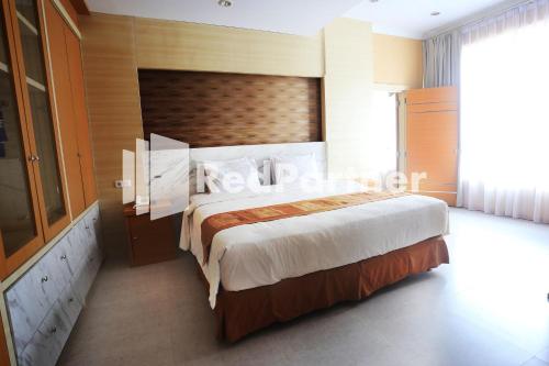 1 dormitorio con 1 cama grande en una habitación en Edotel Syariah Nilam Sari Mitra RedDoorz, en Pekanbaru