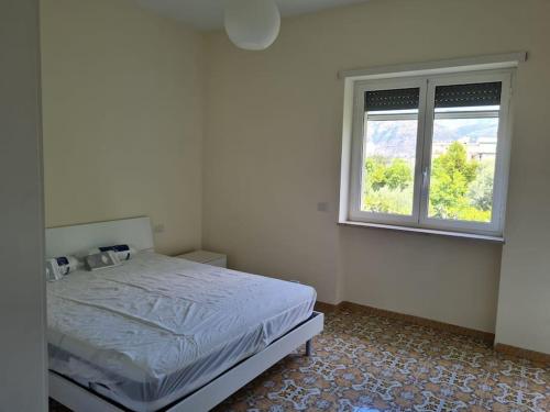 um quarto branco com uma cama e uma janela em casa pagliara em Sorrento