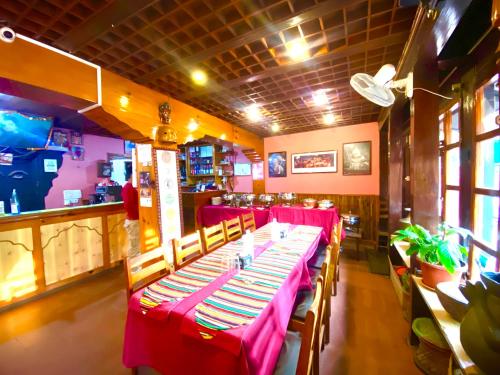 Shiva Guest House في بهاكتابور: غرفة طعام مع طاولات حمراء وكراسي في مطعم