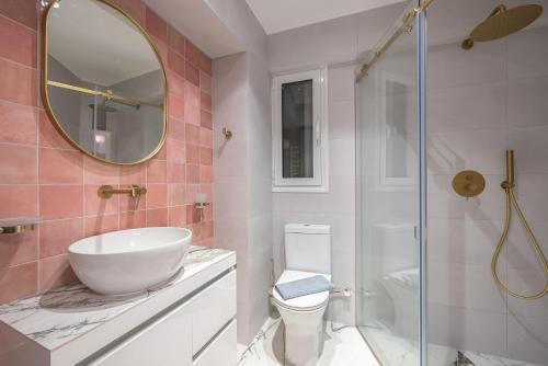 een badkamer met een wastafel, een toilet en een spiegel bij The Courtyard Oasis in Athene