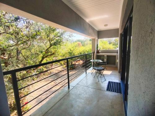 a room with a balcony with a table and a view at Giraffe Studio @ Kruger in Marloth Park