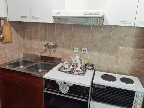 a kitchen with a sink and a stove at Sailor's Rustic House in Virpazar