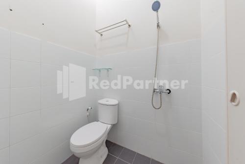 a white bathroom with a toilet and a shower at 158 Guest House Mitra RedDoorz in Bandung