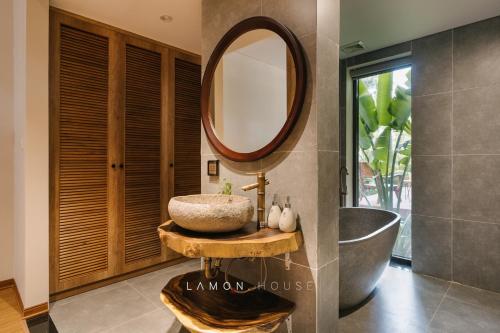 a bathroom with a sink and a large mirror at LaMon House - Venuestay in Hòa Bình