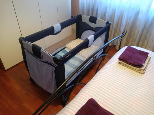 a baby crib in a room next to a bed at Il Cedro Argentato in Monza