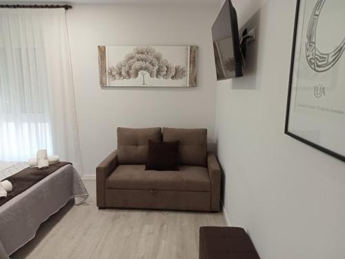 sala de estar con sofá y silla en Baixo a Lua Rooming, en Sarria