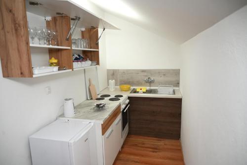 a kitchen with white cabinets and a stove top oven at Apartman Sena in Laktaši