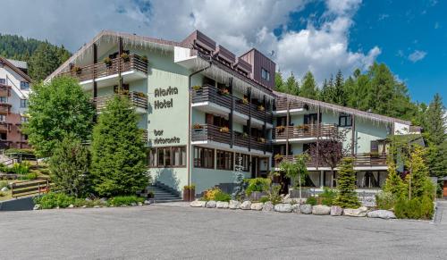 een groot appartementencomplex met een parkeerplaats bij Hotel Alaska in Folgarida