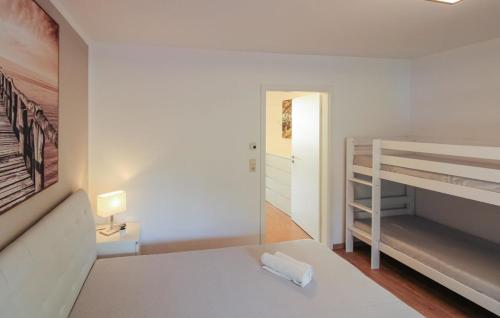 a white bedroom with a bed and a bunk bed at 2-Raum Appartement Saxo in Sankt Englmar