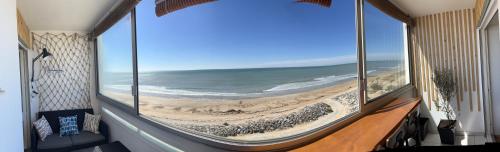 une chambre avec vue sur une plage depuis une fenêtre dans l'établissement face mer, à Saint-Hilaire-de-Riez