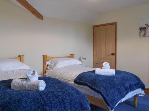 um quarto com duas camas com cobertores azuis em Barnscliff Heights em Broxa